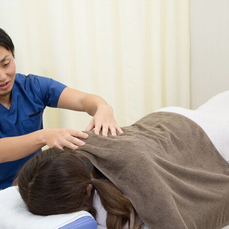 肩の施術を行う男性スタッフ