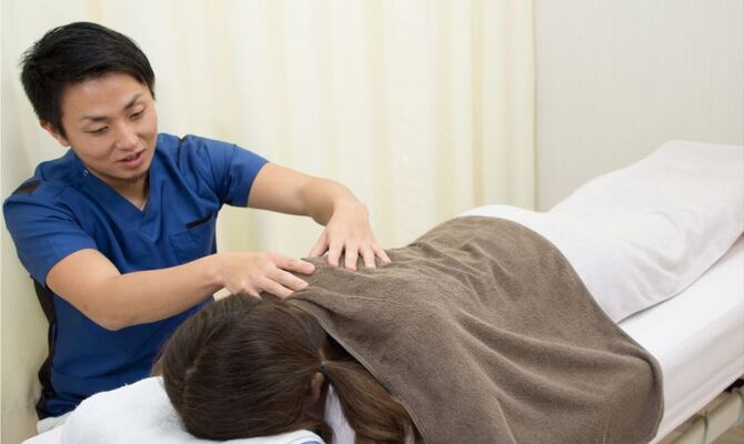 肩の施術を行う男性スタッフ