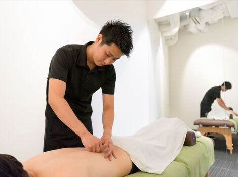 鍼治療中を行う男性スタッフ